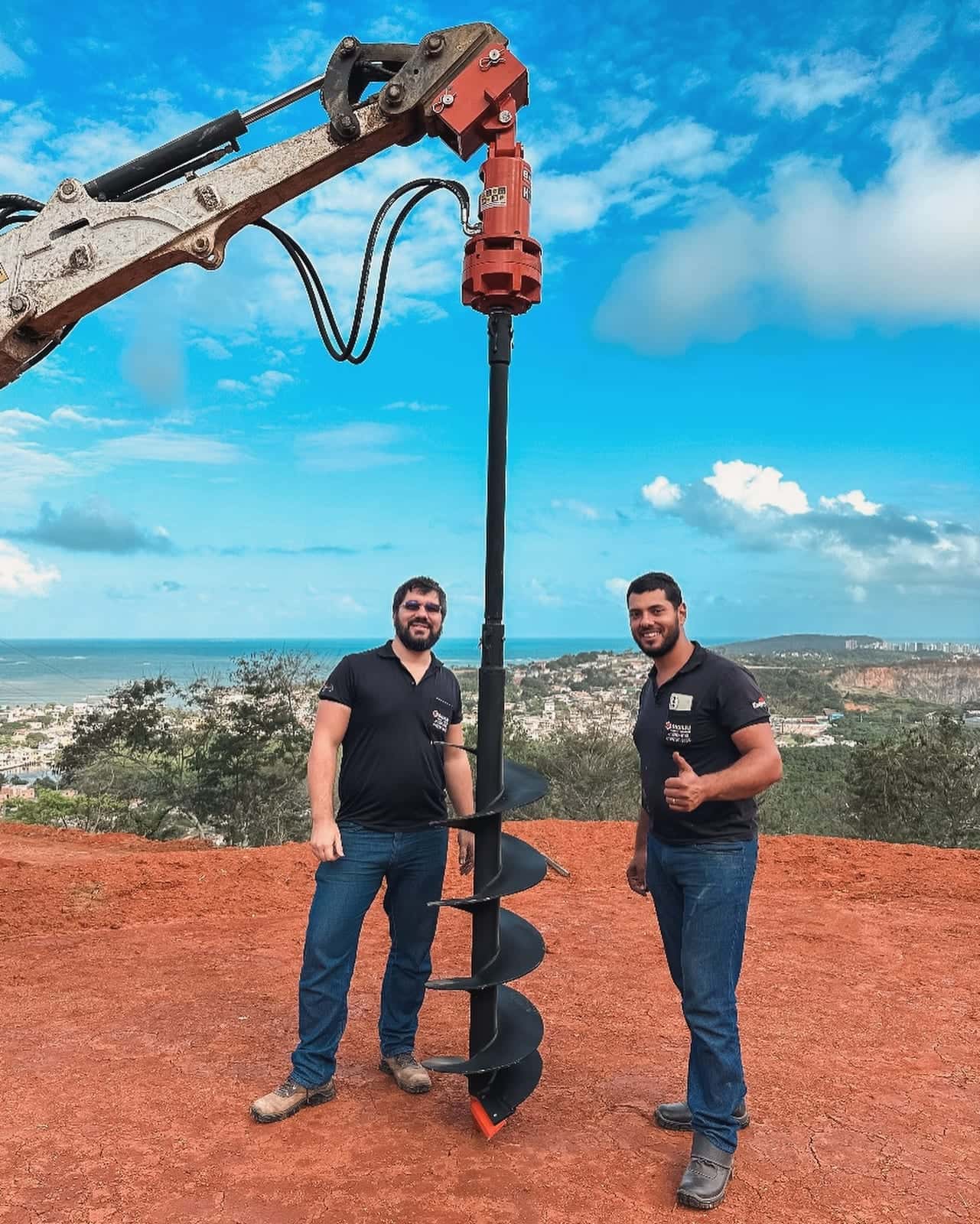 Os sócios da Ricieri ao lado da mini escavadeira com broca de perfuração